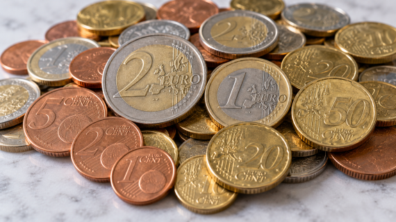 A pile of mixed euro coins for exchange on a counter top